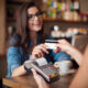 happy-woman-paying-cafe-by-credit-card